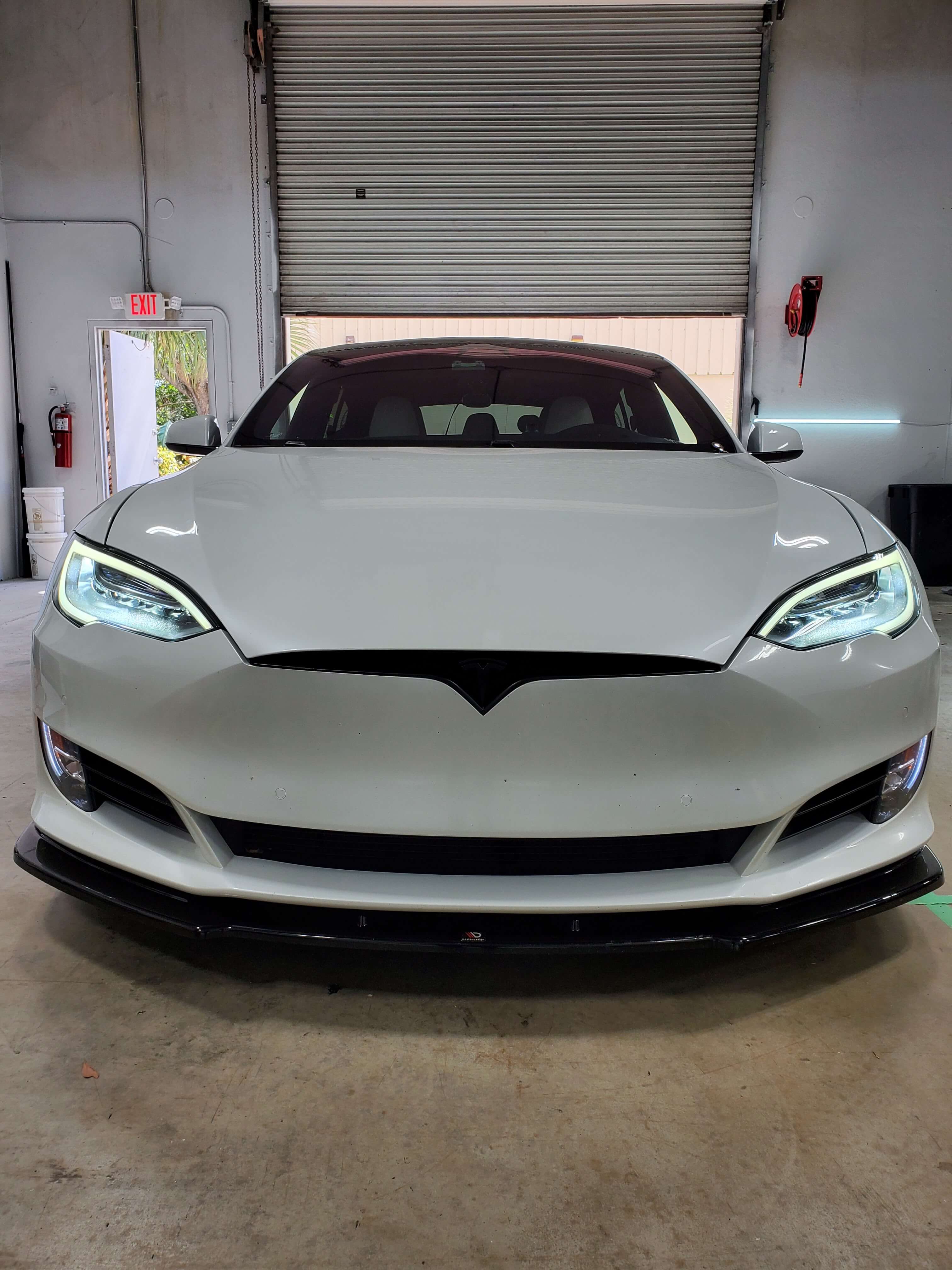 White Tesla inside an Electrified Garage service bay.